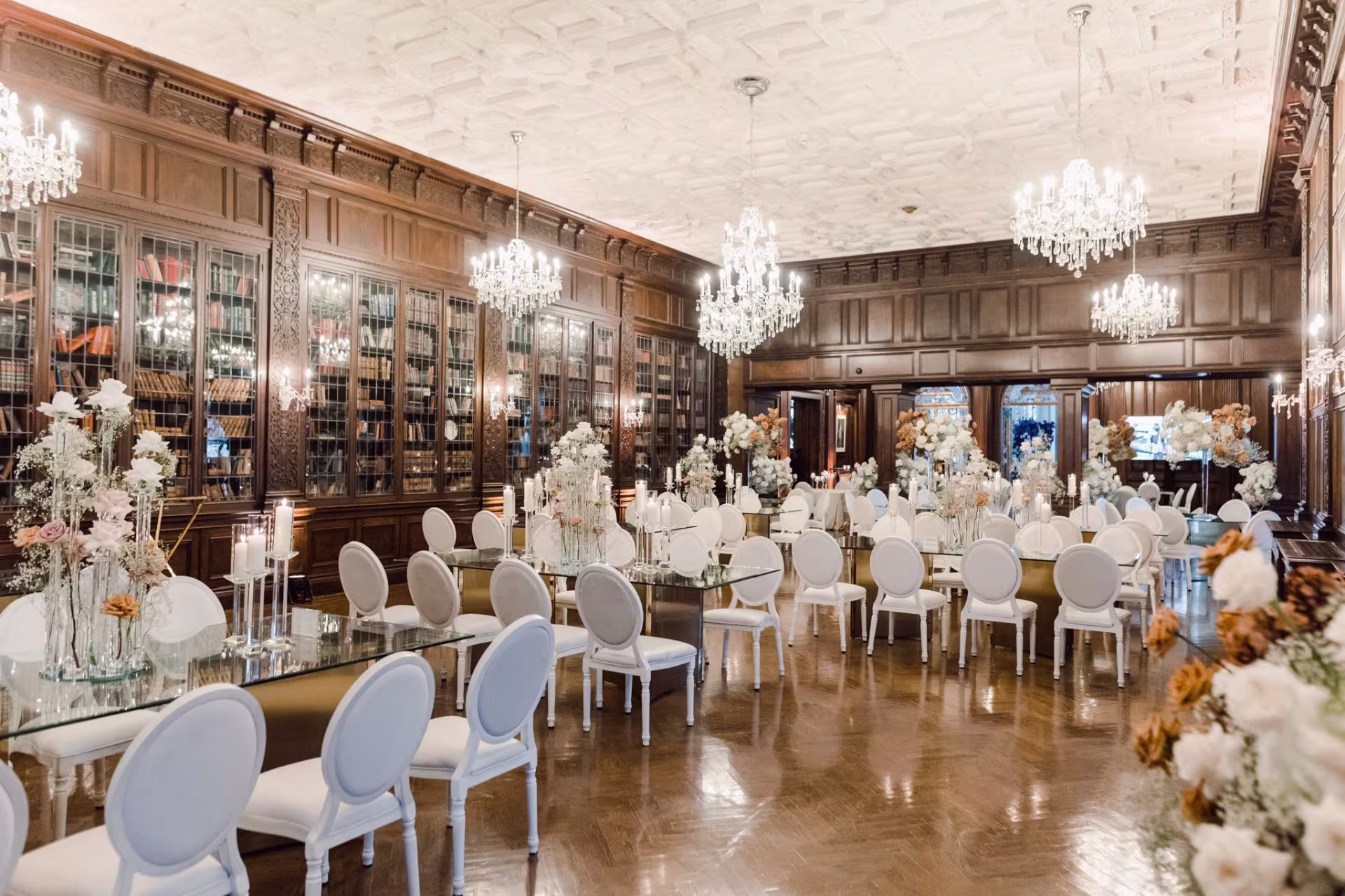 Bespoke Event Rentals Gallery highlighting a luxury wedding reception with long tables, white chairs, and chandeliers